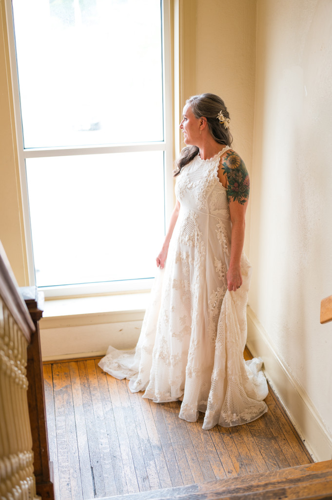 Bride looking out window at Art