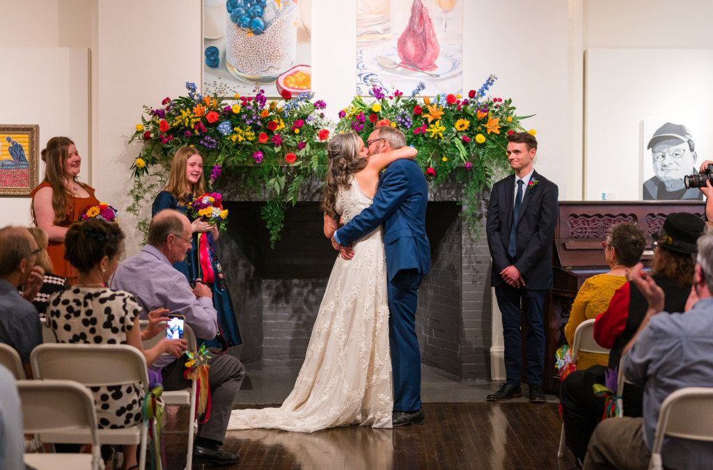 Bride and Groom kissing in art gallery wedding